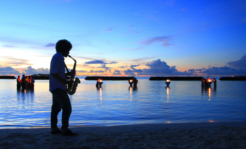 A man playing saxophone at vibrant sunset