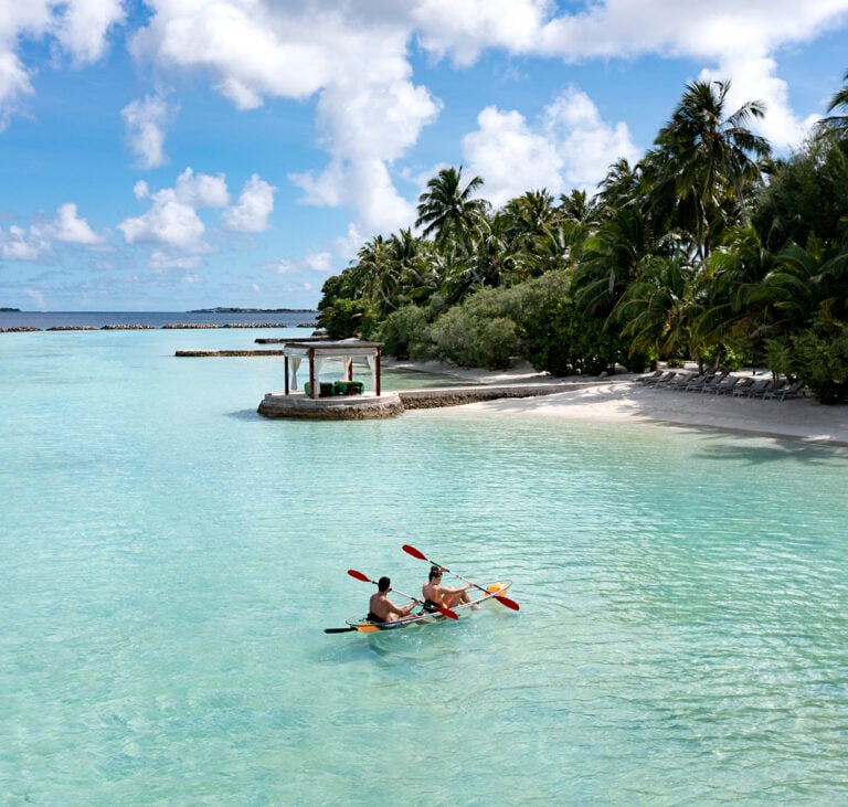 Two people kayaking on clear turquoise water
